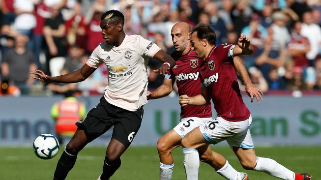 Gelandang Manchester United Paul Pogba mengontrol bola di bawah tekanan gelandang  West Ham United, Mark Noble dan bek  West Ham United Pablo Zabaleta saat pertandingan sepak bola Liga Inggris antara West Ham United melawan Manchester United di London Stadion, London, Inggris, Sabtu (29/9). [AFP/Ian KINGTON]
