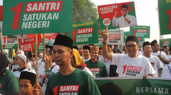 Sejumlah santri mengikuti jalan sehat sarungan di kawasan Monas, Jakarta, Minggu (30/9). [Suara.com/Oke Dwi Atmaja]