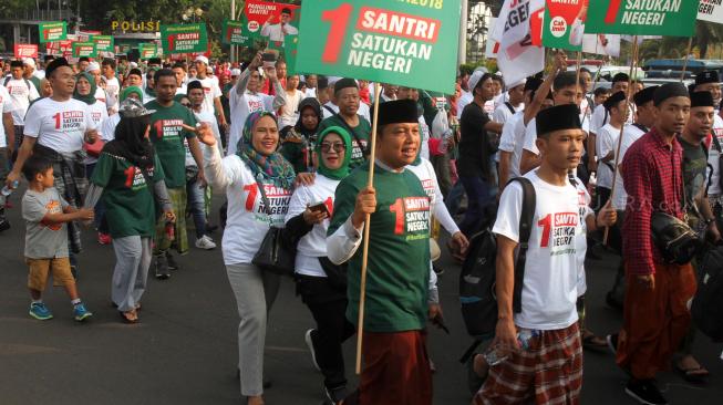 Sejumlah santri mengikuti jalan sehat sarungan di kawasan Monas, Jakarta, Minggu (30/9). [Suara.com/Oke Dwi Atmaja]