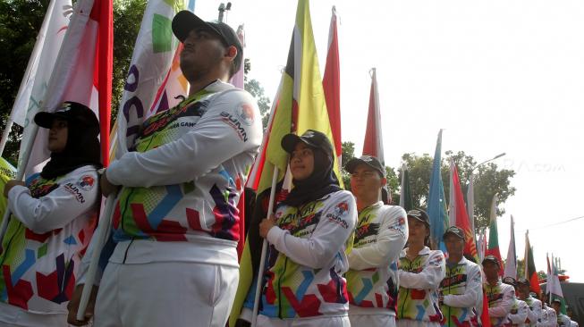 Suasana pawai obor Asian Para Games 2018 ketika melintas di kawasan Jalan Medan Merdeka Selatan, Jakarta, Minggu (30/9). [Suara.com/Oke Dwi Atmaja]