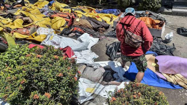 Warga mencari korban gempa dan tsunami yang tewas di RS Bhayangkara, Palu, Sulawesi Tengah, Minggu (30/9).[ANTARA FOTO/Muhammad Adimaja]