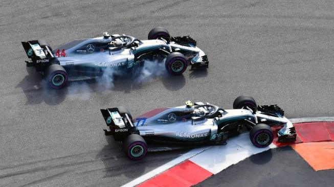 Pebalap Mercedes, Valtteri Bottas (kanan), berduel dengan rekannya Lewis Hamilton pada balapan F1 GP Rusia di Sirkuit Sochi, Minggu (30/9/2018). [AFP/Andrej Isakovic]