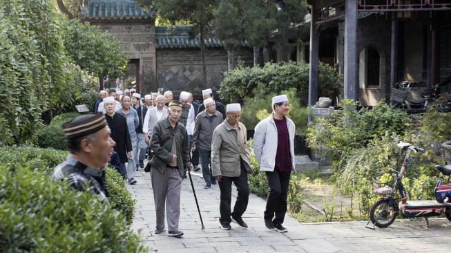 Umat muslim berjalan ke luar areal masjid usai menjalankan ibadah salat di Mesjid Agung, di kawasan komunitas muslim di Xi'an, Cina, Sabtu (29/9). [ANTARA FOTO/Hermanus Prihatna]