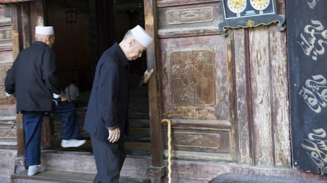 Dua umat muslim masuk ke dalam masjid saat akan menjalankan ibadah salat di Mesjid Agung, di kawasan komunitas muslim di Xi'an, Cina, Sabtu (29/9). [ANTARA FOTO/Hermanus Prihatna]