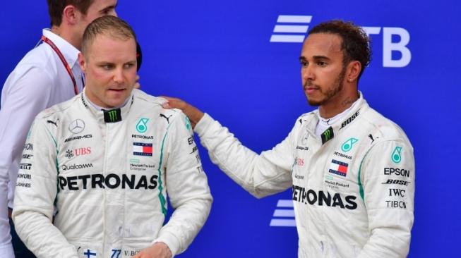 Duet pebalap Mercedes, Lewis Hamilton (kanan) dan Valtteri Bottas, berada di podium F1 GP Rusia di Sirkuit Sochi, Minggu (30/9/2018). [AFP/Andrej Isakovic]