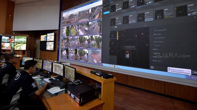 Petugas Traffic Management Center (TMC) memantau pelanggar lalu lintas melalui layar CCTV di ruas jalan Thamrin-Sudirman di ruang kontrol Polda Metro Jaya, Jakarta, Senin (1/10).  [Suara.com/Muhaimin A Untung] 