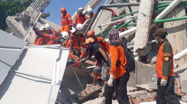 Tim SAR melakukan evakuasi korban gempa yang tertimbun reruntuhan bangunan Hotel Roa-Roa di Palu, Sulawesi Tengah, Minggu (30/9). Diperkirakan sebanyak 50 orang tertimbun di reruntuhan bangunan hotel itu. [Antara/BNPB]