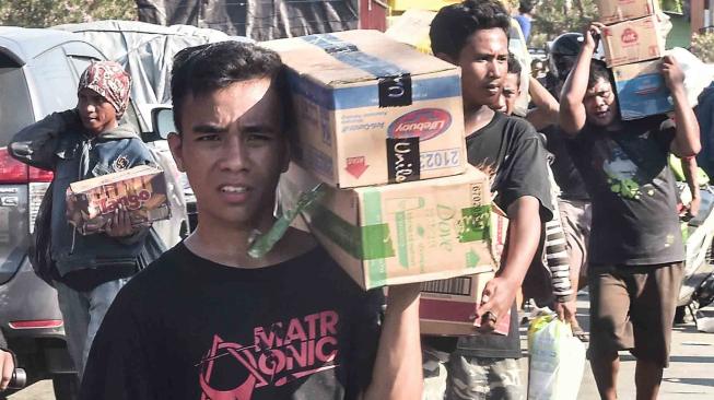 Warga membawa sejumlah barang dari gudang Alfa Midi di Mamboro, Palu Utara, Sulawesi Tengah, Senin (1/10). [ANTARA FOTO/Muhammad Adimaja]