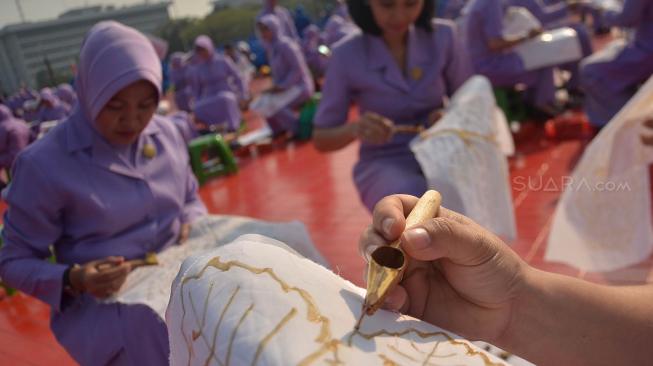 Ribuan anggota Dharma Pertiwi TNI mengikuti pemecahan rekor MURI membatik dengan canting di Mabes TNI Cilangkap, Jakarta, Selasa (2/10). [Suara.com/Muhaimin A Untung] 
