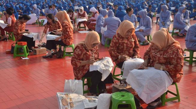 Ribuan anggota Dharma Pertiwi TNI mengikuti pemecahan rekor MURI membatik dengan canting di Mabes TNI Cilangkap, Jakarta, Selasa (2/10). [Suara.com/Muhaimin A Untung] 
