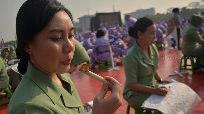 Ribuan anggota Dharma Pertiwi TNI mengikuti pemecahan rekor MURI membatik dengan canting di Mabes TNI Cilangkap, Jakarta, Selasa (2/10). [Suara.com/Muhaimin A Untung] 
