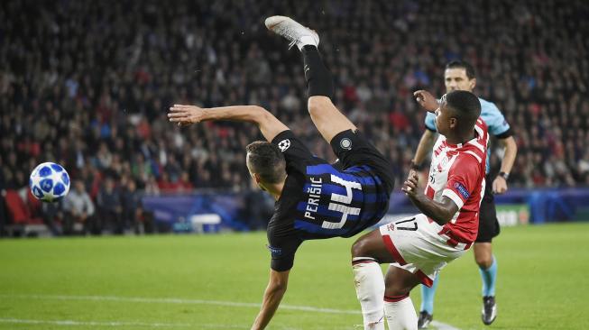 Pemain tengah Inter Milan Ivan Perisic terjatuh saat melewati pemain PSV Eindhoven, Steven Bergwijn selama pertandingan Grup B Liga Champions anatar PSV Eindhoven melawan Inter Milan di Stadion Philips, Eindhoven, Belanda, Rabu (3/9). [AFP/JOHN THYS].