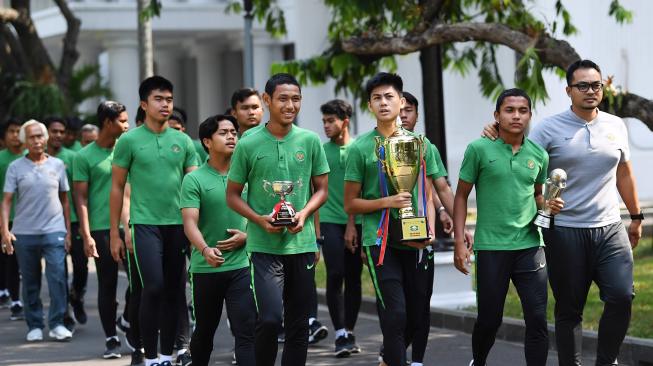 Pemain Timnas U-16 serta tim ofisial berjalan dengan membawa piala sebelum bertemu dengan Presiden Joko Widodo di Istana Merdeka, Jakarta, Kamis (4/10). [ANTARA FOTO/Wahyu Putro]