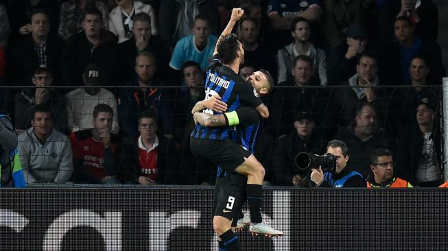 Pemain depan Inter Milan Mauro Icardi merayakan bersama gelandang Inter Milan Matteo Politano setelah mencetak gol selama pertandingan Grup B Liga Champions antara PSV Eindhoven melawan Inter Milan di Stadion Philips, Eindhoven, Belanda, Rabu (3/10). [AFP/JOHN THYS].