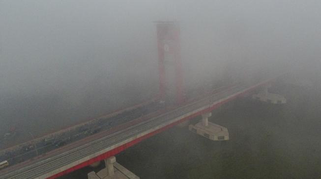 Sejumlah kendaraan melintas di atas jembatan Ampera yang tertutup kabut asap di Palembang, Sumatera Selatan, Jumat (5/10). [ANTARA FOTO/Nova Wahyudi]