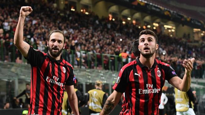 Pemain depan AC Milan asal Argentina Gonzalo Higuain (kiri) dan pemain depan AC Milan Patrick Cutrone, merayakan gol setelah Higuain mencetak gol saat pertandingan sepak bola Grup F Liga Europa antara AC Milan melawan Olympiakos di stadion San Siro, Milan, Italia, Kamis (4/9). [AFP/Miguel MEDINA]