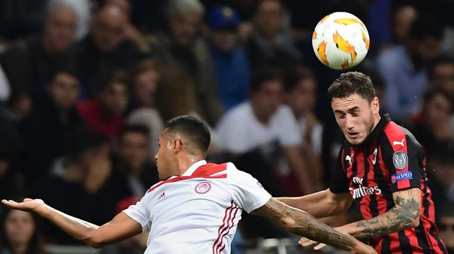 Gelandang Olympiakos Nahuel Leiva (kiri) dan bek AC Milan Davide Calabria mencoba melakukan sundulan selama pertandingan sepak bola Grup F Liga Europa antara AC Milan melawan Olympiakos di stadion San Siro, Milan, Italia, Kamis (4/9). [AFP/Miguel MEDINA]