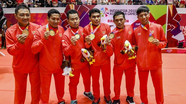 Tim bulu tangkis beregu putra Indonesia Asian Para Games 2018 berfoto bersama usai meraih medali emas cabang olahraga para bulu tangkis Asian Para Games 2018 di Istora Senayan, Jakarta, Minggu (7/10). [ ANTARA FOTO/Galih Pradipta]