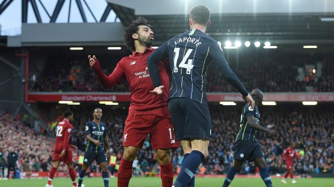 Striker Liverpool Mohamed Salah berdebat dengan bek Manchester City Aymeric Laporte selama pertandingan sepak bola Liga Inggris antara Liverpool melawan Manchester City di Stadion Anfield, Liverpool, Inggris, Minggu (7/10). [AFP/Paul ELLIS]
