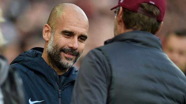 Manajer Manchester City Pep Guardiola (kiri) berjabat tangan dengan manajer Liverpool saat kedua tim berjumpa di Anfield.Paul ELLIS / AFP 