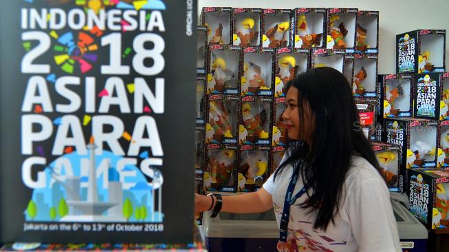 Pengunjung melihat merchandies Maskot Momo Asian Para Games di toko, kawasan Gelora Bung Karno , Jakarta, Senin (8/10). [Suara.com/Muhaimin A Untung]