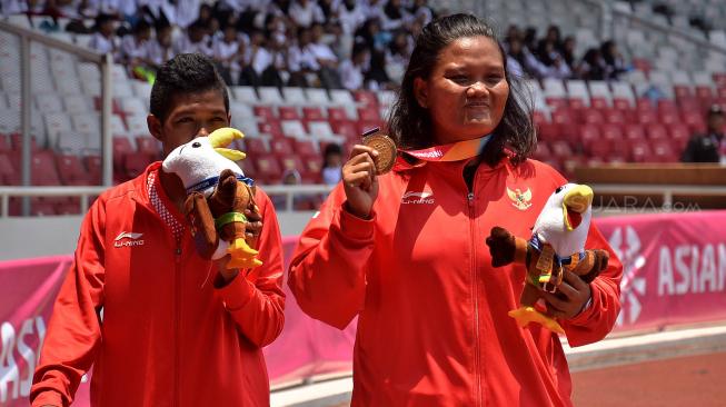 Atlet Indonesia Suparniyati (kanan) dan Tiwa meluapkan kegembiraan seusai bertanding pada babak final para atletik nomor tolak peluru F20 putri Asian Para Games 2018 di Stadion Utama GBK, Jakarta, Senin (8/10). [Suara.com/Muhaimin A Untung]