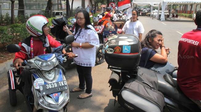 Driver Ojek Disabilitas menawarkan jasa kepada pengunjung di Kompleks Gelora Bung Karno,Senayan,Jakarta Pusat (8/10). [Suara.com/Fakhri Hermansyah]
