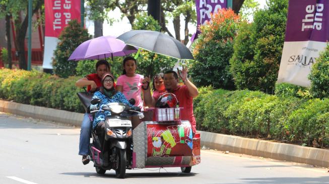 Driver Ojek disabilitas mengantarkan sejumlah keluarga di Kompleks Gelora Bung Karno,Senayan,Jakarta Pusat (8/10). [Suara.com/Fakhri Hermansyah]