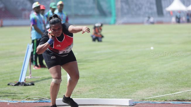 Atlet Indonesia Suparniyati mengambil ancang-ancang saat berlaga pada babak final para atletik nomor tolak peluru F20 putri Asian Para Games 2018 di Stadion Utama GBK, Jakarta, Senin (8/10). [Suara.com/Muhaimin A. Untung]