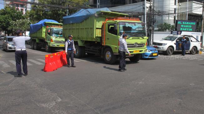 Sejumlah Petugas Dishub melakukan sosialisasi uji Coba Sistem satu arah Jalan KH Wahid Hasyim, Jakarta Pusat, Senin (8/10). [Suara.com/Fakhri Hermansyah]