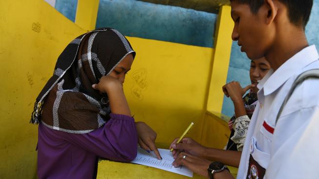 Siswa mendata rekannya saat hari pertama masuk sekolah di SMA PGRI, Palu, Sulawesi Tengah, Senin (8/10). [ANTARA FOTO/Wahyu Putro]
