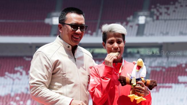 Menpora Imam Nahrawi (kiri) berpose usai memberikan  medali para atletik nomor lompat jauh putri T20 Asian Para Games 2018 kepada Atlet Indonesia Rica Oktavia (tengah) di Stadion Utama GBK, Jakarta, Senin (8/10). [Suara.com/Muhaimin A Untung]
