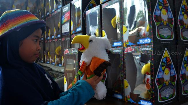 Pengunjung melihat merchandies Maskot Momo Asian Para Games di toko, kawasan Gelora Bung Karno , Jakarta, Senin (8/10). [Suara.com/Muhaimin A Untung]