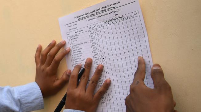 Siswa mendata rekannya saat hari pertama masuk sekolah di SMA PGRI, Palu, Sulawesi Tengah, Senin (8/10). [ANTARA FOTO/Wahyu Putro]
