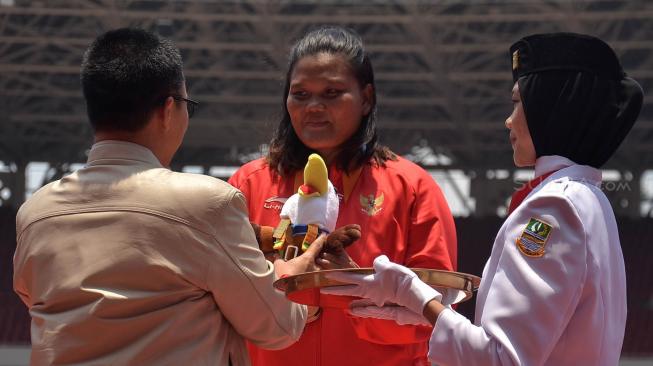 Menteri Pemuda dan Olahraga Imam Nahrawi suvenir ke Atlet Indonesia Suparniyati di Stadion Utama GBK, Jakarta, Senin (8/10). [Suara.com/Muhaimin A Untung]
