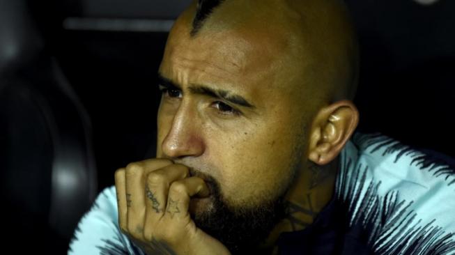 Gelandang Barcelona Arturo Vidal di bangku cadangan menyaksikan skuatnya bermain menghadapi Valencia di Mestalla. JOSE JORDAN / AFP