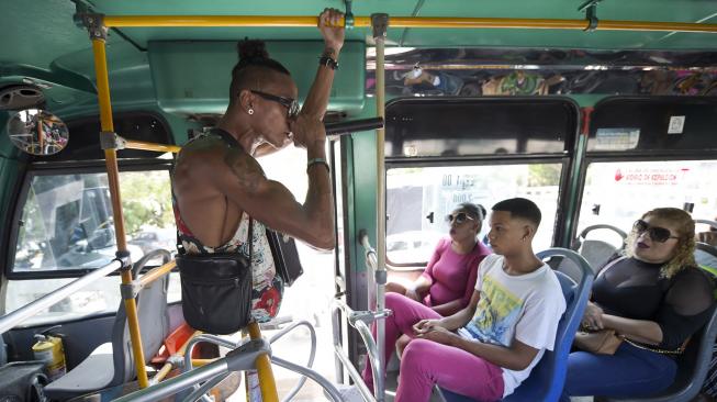 Alfonso Mendoza (Alca) saat menghibur penumpang di dalam bus, Barranquilla, Kolombia, Jumat (28/9). [AFP/ARBOLDA]