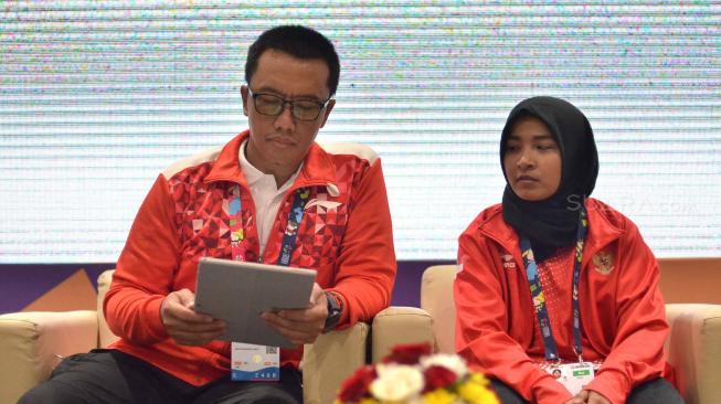 Menteri Pemuda dan Olahraga Imam Nahrawi bersama Atlet judo Indonesia Asian Para Games Miftahul Jannah saat memberikan keterangan pers mengenai dirinya yang telah didiskualifikasi karena tidak mau melepas jilbab di Gedung GBK Arena, Jakarta, Selasa (9/10). [Suara.com/Muhaimin A Untung]