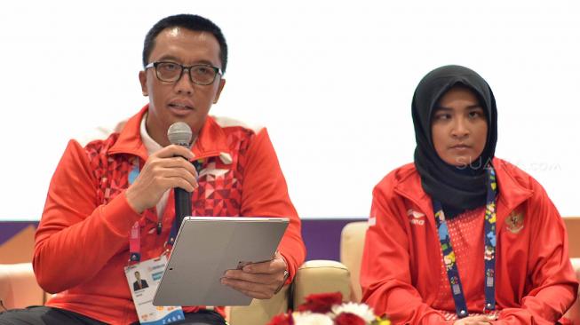 Menteri Pemuda dan Olahraga Imam Nahrawi bersama Atlet judo Indonesia Asian Para Games Miftahul Jannah saat memberikan keterangan pers mengenai dirinya yang telah didiskualifikasi karena tidak mau melepas jilbab di Gedung GBK Arena, Jakarta, Selasa (9/10). [Suara.com/Muhaimin A Untung]