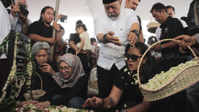 Indro Warkop saat pemakaman istrinya Almarhumah Nita Octobijanthy bersama  putrinya  Satya Paramitha Hada di TPU Tanah Kusir, Jakarta Selatan, Rabu (10/10). (Suara.com/Fakhri Hermansyah)