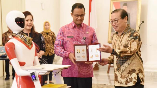 Gubernur DKI Jakarta Anies Baswedan (kiri) bersama Ketua Yayasan Pendidikan Robotik Indonesia Wahidin Wahab (kanan) saat penandatanganan kerjasama di ruang Balairung, Balai Kota, Jakarta Pusat, Kamis (11/10).  (Suara.com/Fakhri Hermansyah) 