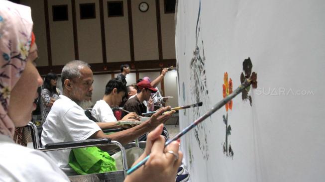 Penyandang disabilitas melukis di kanvas di Balai Agung, Jakarta, Kamis (11/10). (Suara.com/Fakhri Hermansyah)