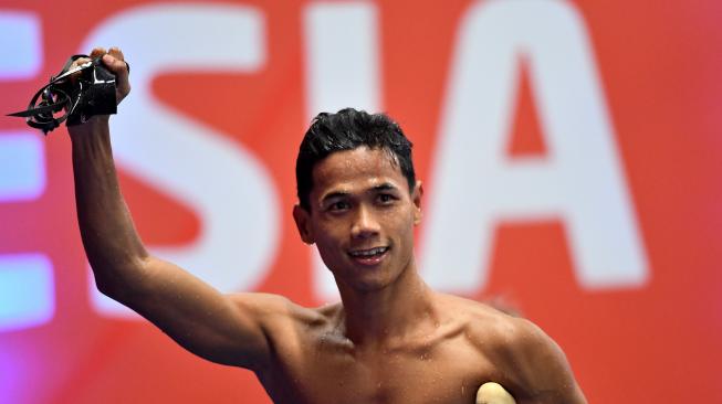 Perenang Indonesia Jendi Pangabean berselebrasi usai finish terdepan dalam nomor renang 100 meter gaya punggung putra S9 Asian Para Games 2018 di Stadion Akuatik, Senayan, Jakarta, Kamis (11/10). [ANTARA FOTO/Akbar Nugroho Gumay]