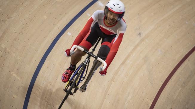 Atlet Indonesia Muhammad Fadli Immamuddin memacu kecepatannya pada sesi perebutan medali perunggu balap sepeda trek putra beregu klasifikasi C1-C5 Asian Para Games 2018 di Jakarta International Velodrome, Rawamangun, Jakarta, Kamis (11/10). [Antara/Aprillio Akbar]