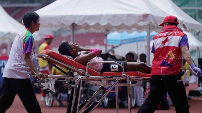 Atlet para atletik putri Tiwa diatandu keluar lintasan usai lari 1.500 meter di klasifikasi cacat intelektual (T20) Asian Para Games 2018 di Stadion Utama Gelora Bung Karno (SUGBK), Jakarta, Jumat (12/10).  [Suara.com/Muhaimin A Untung] 