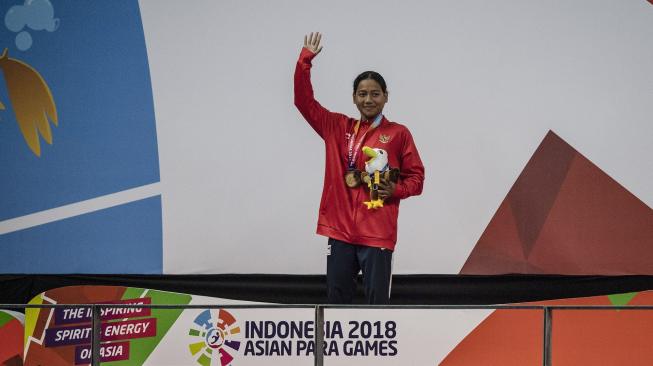 Atlet Indonesia Suci Indriani meluapkan kegembiraannya seusai menang dalam babak final renang gaya dada klasifikasi SB14 Asian Para Games 2018 di Stadion Akuatik Gelora Bung Karno, Jakarta, Senin (8/10). [ANTARA FOTO/Aprillio Akbar]