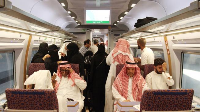 Para penumpang menaiki kereta api kecepatan tinggi Haramain yang resmi beroperasi di Stasiun kereta Mekah, Arab Saudi, Kamis (11/10). [Afp Photo/Bandar Aldandani]