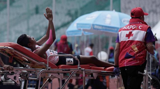 Atlet para atletik putri Tiwa diatandu keluar lintasan usai lari 1.500 meter di klasifikasi cacat intelektual (T20) Asian Para Games 2018 di Stadion Utama Gelora Bung Karno (SUGBK), Jakarta, Jumat (12/10).  [Suara.com/Muhaimin A Untung] 