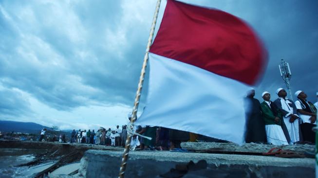 Sejumlah umat muslim melakukan zikir dan doa bersama untuk korban gempa dan tsunami Palu-Donggala di Anjungan Nusantara Pantai Talise Palu, Sulawesi Tengah, Jumat (12/10). [ANTARA FOTO]