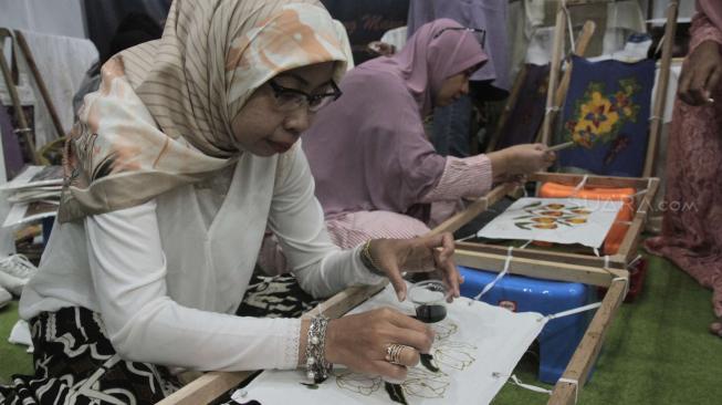 Pengunjung belajar kerajinan batik tulis kembang Mayang pada pameran Crafina di JCC, Senayan, Jakarta Pusat, Minggu (14/10). (Suara.com/Fakhri Hermansyah)